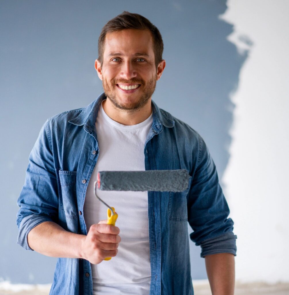 Happy man having fun painting his house