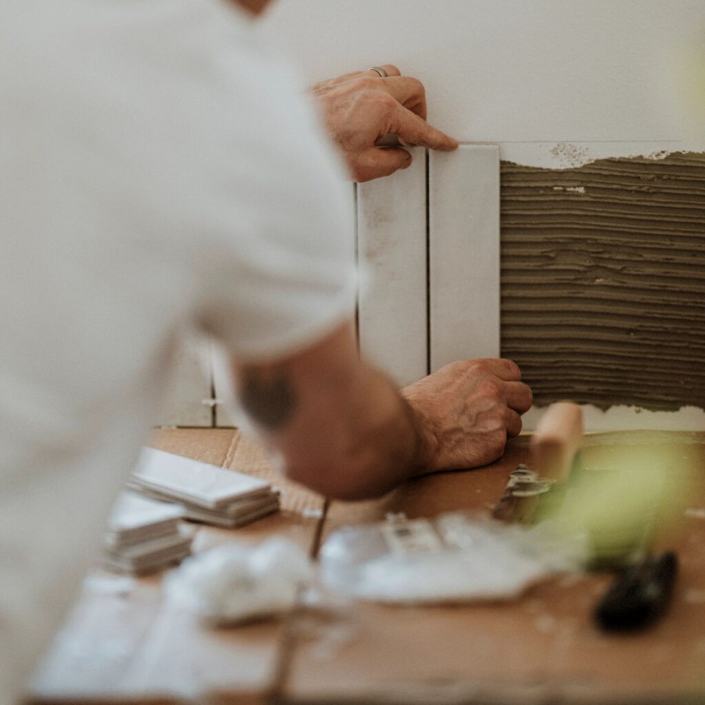Man putting up tile in kitchen